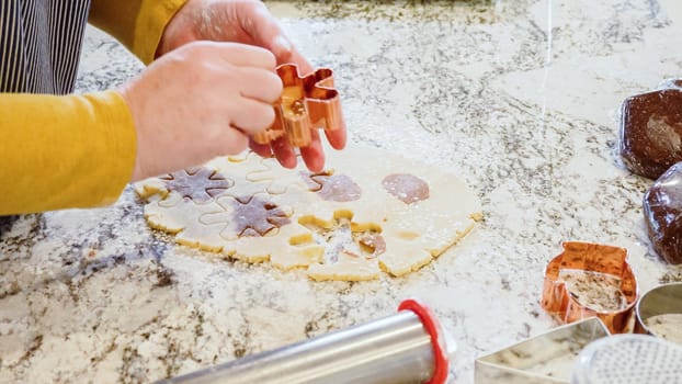 Using various festive cookie cutters, we're cutting out charming gingerbread cookies from the rolled dough on the sleek marble counter, bringing holiday cheer to the modern kitchen.