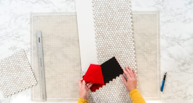 In the process of mounting peel and stick mosaic tiles onto a foam board, perfect for enhancing a food photography studio's aesthetic.