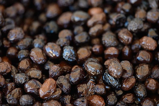 Vibrant dried olives capture attention at a bustling market, showcasing their rich colors and textures under the sun.