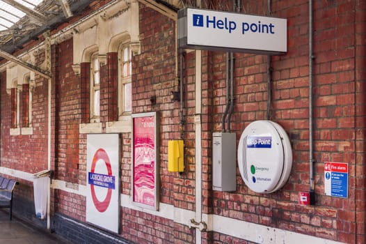 London, UK Ladbroke Grove Tube station empty platform with Help point station signage and brick walls.