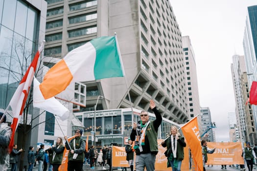 Participants waving Irish flags during a lively city parade of joy and unity