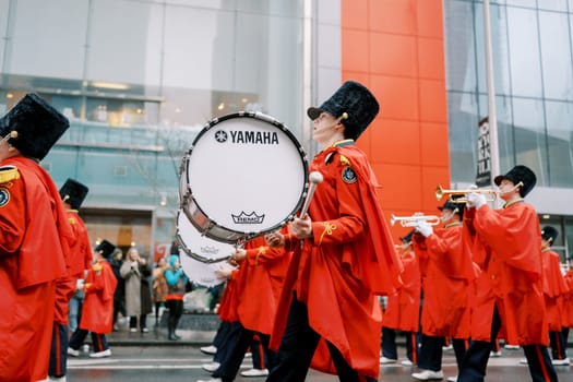 Marching band performing in the city during a colorful parade celebration