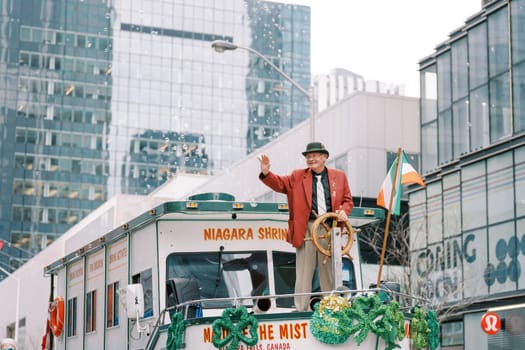 A festive outdoor event with a lively performer on a float at the city parade
