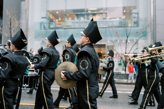 A vibrant marching band showcases exceptional skills at a city parade, full of joy