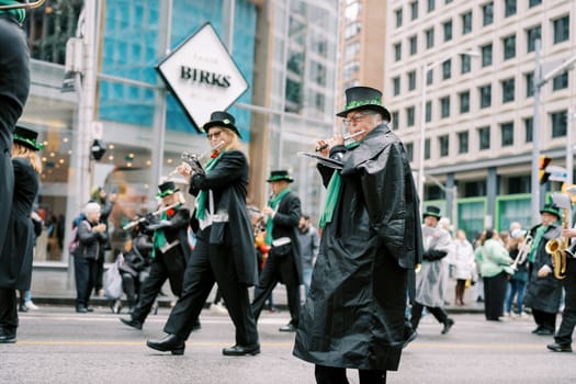 The festive parade includes musicians and participants in vibrant attire