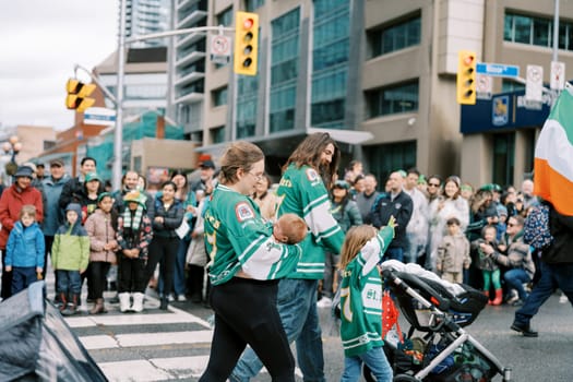Families enjoy a cultural parade with vibrant green jerseys and excitement