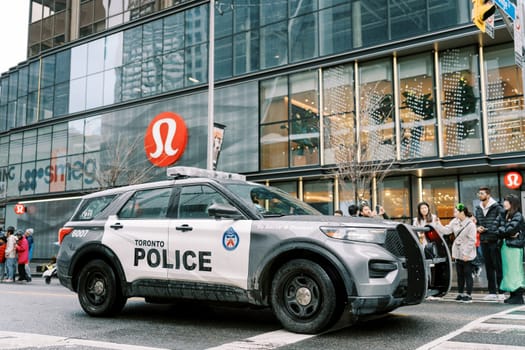A police SUV skillfully navigates a bustling urban area filled with pedestrians