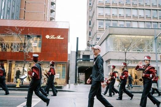 A vibrant marching band performs in a city parade, showcasing local culture