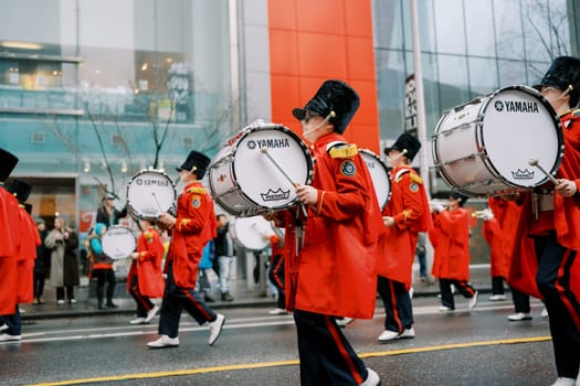 A colorful parade with enthusiastic drummers in vibrant red attire, creating energy