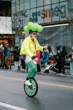 A colorful unicyclist delights the crowd with unique skills at the festive event