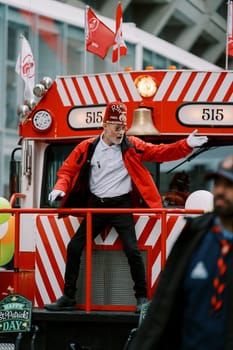 An energetic performer joyfully celebrates while riding on a vibrant parade float