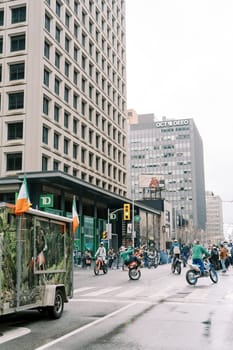 An urban parade is showcasing motorcycles in a vibrant city environment