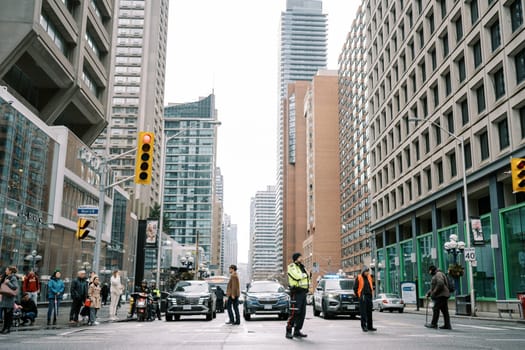 A busy city traffic scene with officers managing vehicles and pedestrians for safety