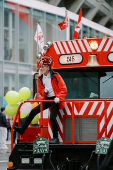 A lively performer enjoys a festive parade on a vibrant train full of joy