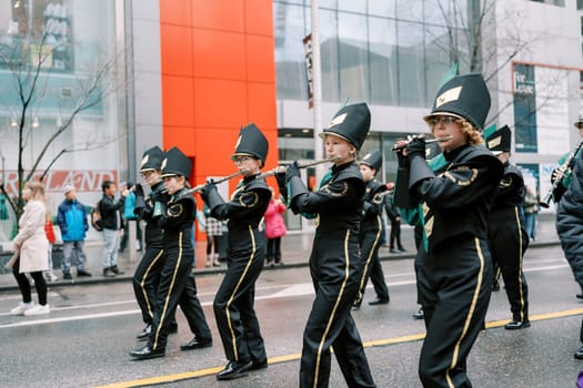 A dynamic marching band performs in a lively atmosphere at a city parade