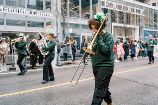 A lively marching band parade with a talented trombonist on busy city streets