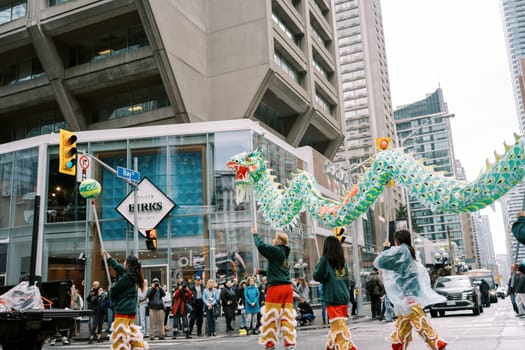 A vibrant dragon dance takes center stage in a lively city parade celebration
