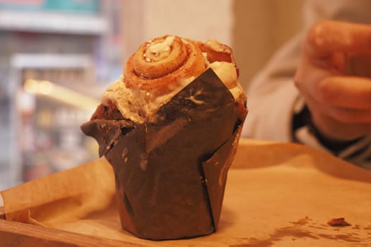 Freshly baked muffin with cinnamon swirl on top rests on a tray.