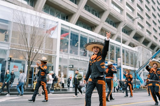 Vibrant parade featuring dancers in traditional costumes against city backdrop