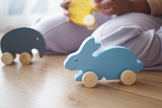 A child interacts with vibrant wooden toys in a bright room.