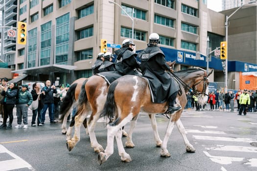 Mounted police are currently on patrol in a bustling and lively city street area