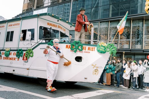 A festive parade features a cheerful clown and a decorated boat, celebrating culture