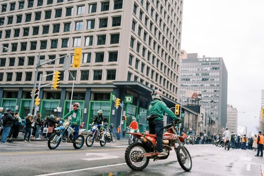 Motorcyclists happily take part in a vibrant city parade, even on a rainy day