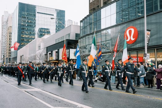 A vibrant parade showcasing uniformed marchers and numerous flags in a city
