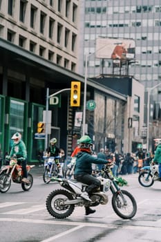 Dirt bikes navigate busy city streets skillfully during a vibrant event