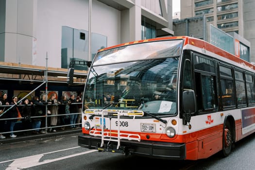 A bus skillfully navigating a vibrant, busy urban street filled with life