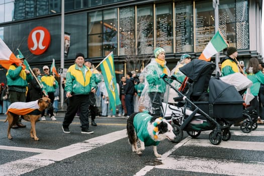 A vibrant parade featuring joyful participants with flags and pets, celebrating community