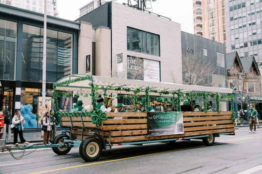 Vibrant float adorned with greenery, bustling city backdrop, community spirit.