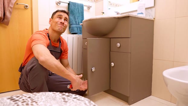 Plumber assesses bathroom sink problem and discusses expensive repair solution with the client