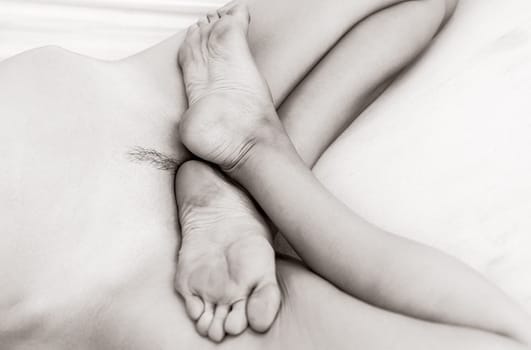 Sensual black and white image of a nude young woman resting in a hammock, creating an intimate and peaceful scene.