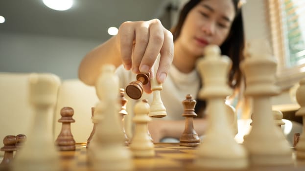 Close up shot of a woman hand placing a chess piece on board.