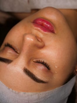 Anti-wrinkle moisturizing gel for the face around the eyes for the eyelids. Women's care at a beautician, close-up, vertical
