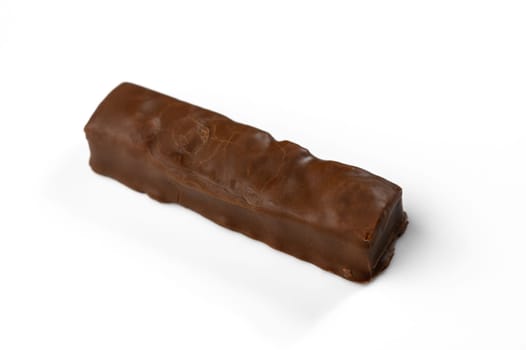 A tempting chocolate bar rests on a clean white surface, inviting indulgence with its smooth texture and rich aroma.