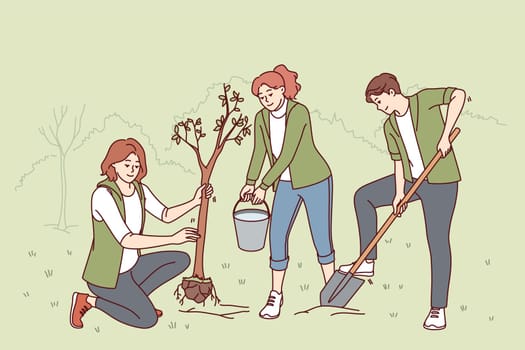 Volunteers plant trees in park and water seedlings to save nature from co2 emissions and climate change. People with paw and bucket for planting trees helping ecology recover after deforestation