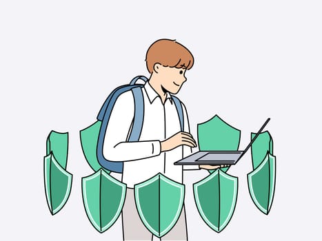 Boy with laptop is learning cyber protect and installing antivirus software standing among green shields. School student uses apps to cyber protect personal data from hackers or viruses