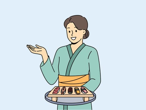 Woman sushi master with maki appetizer on wooden tray dressed in traditional asian kimono. Girl works in japanese food restaurant serving sushi from rice and fresh seafood to visitors.