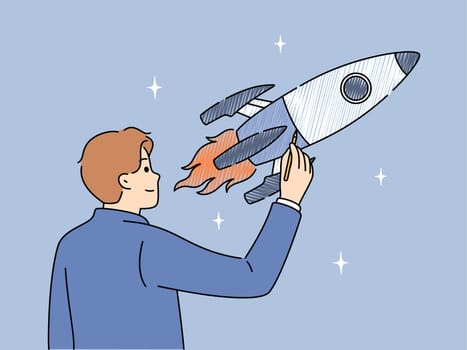 Businessman draws space rocket symbolizing successful launches and business ambitions or striving to achieve goals. Concept of starting and developing your own business or looking for investments