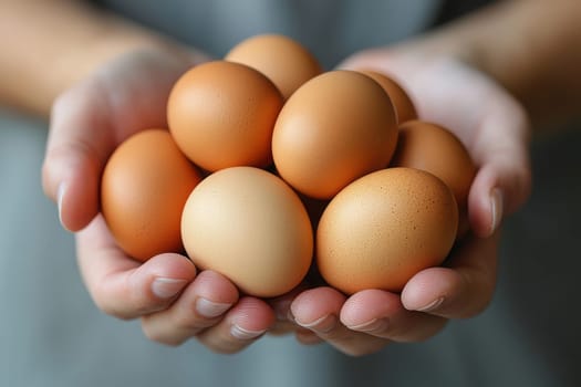 Two hands cradle a cluster of brown eggs, showcasing their smooth texture and natural hues. The setting features soft, natural lighting that highlights the freshness of the eggs.