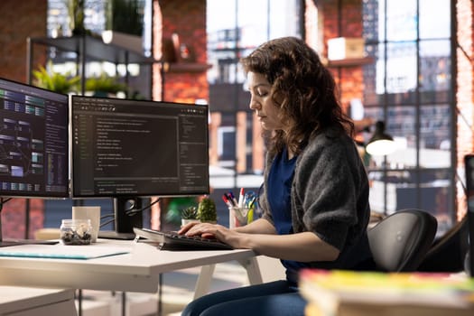 African american software engineer works on dual monitors and typing code for a development project. Technical developer multitasking, debugging and using advanced digital tools for coding.