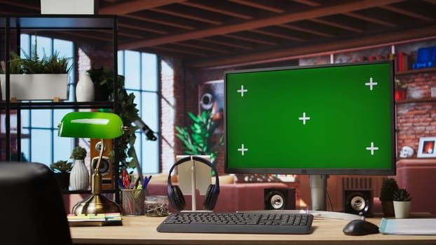 Isolated screen mockup PC on home office desk with stationary items and headphones on, surrounded by plants. Chroma key computer display in loft with shelves filled with books in background