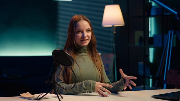 Upbeat content creator in studio filming herself discussing topics of interest for generation Z fanbase. Jolly internet star talking in microphone, recording video targeting gen Z viewers, camera A