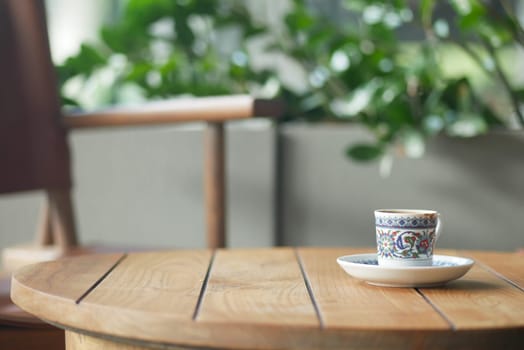 turksih Coffee cup on a wooden table surrounded by greenery.