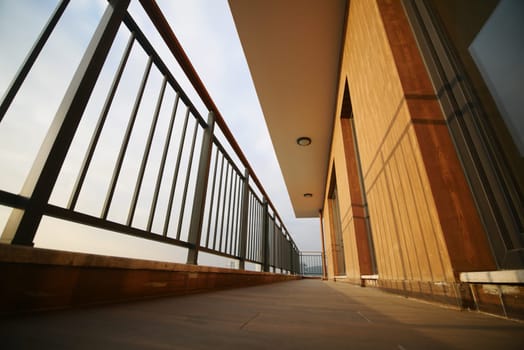 A spacious balcony offers a panoramic view of the horizon at twilight.