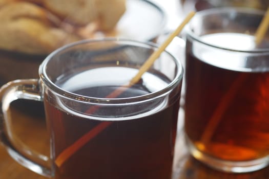 Freshly brewed tea is served in glasses, accompanied by pastries.