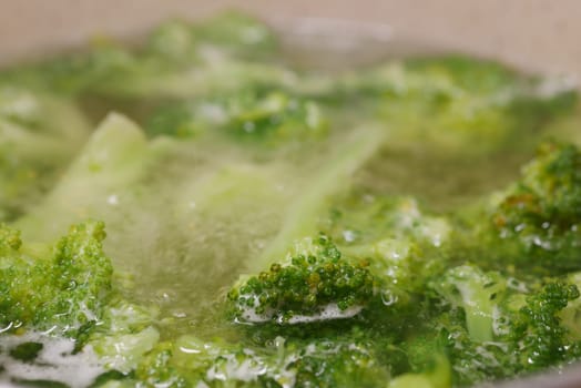 Fresh broccoli is being boiled until tender in a pot of water.