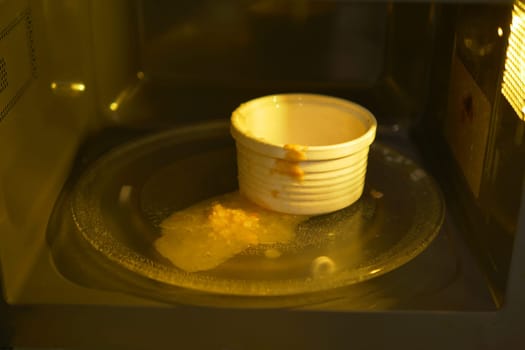 Messy food spills inside a microwave after an overcooked meal.